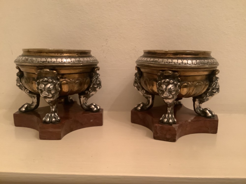 A pair of circular bronze and silvered metal tazzas featuring lion monopodia legs and resting on shaped red marble bases. View II