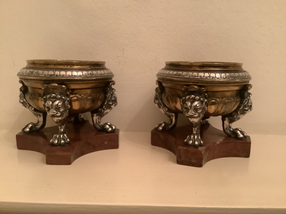 A pair of circular bronze and silvered metal tazzas featuring lion monopodia legs and resting on shaped red marble bases. View V