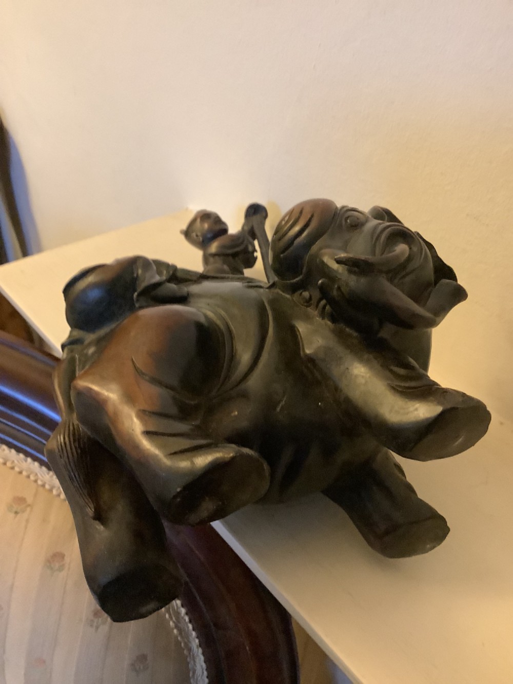 A dark brown patinated bronze sculpture depicting an elephant with two young boys on its back. View VI