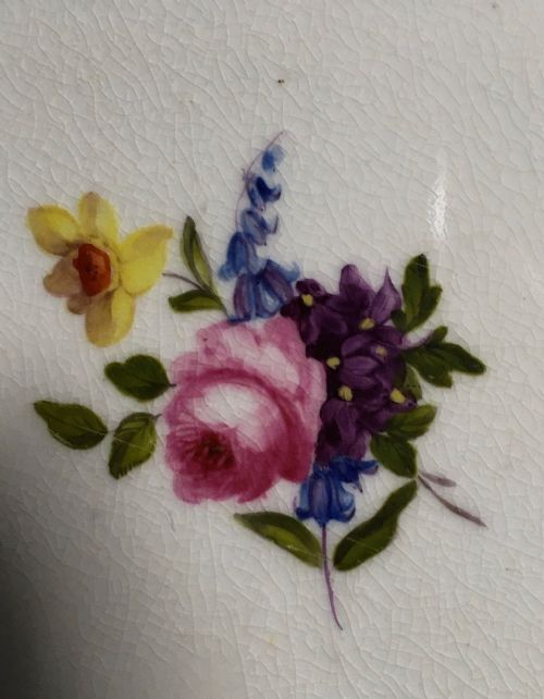 fig 1. A circular Regency period Bloor Derby porcelain dessert plate featuring deep green rim panels, hand-painted floral bouquets, and gilded scrolling borders surrounding a central botanical motif.
