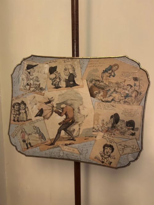 fig 1. A pair of late George III mahogany pole screens featuring adjustable scalloped panels mounted with printed satirical caricatures on turned wooden stands with tripod bases.