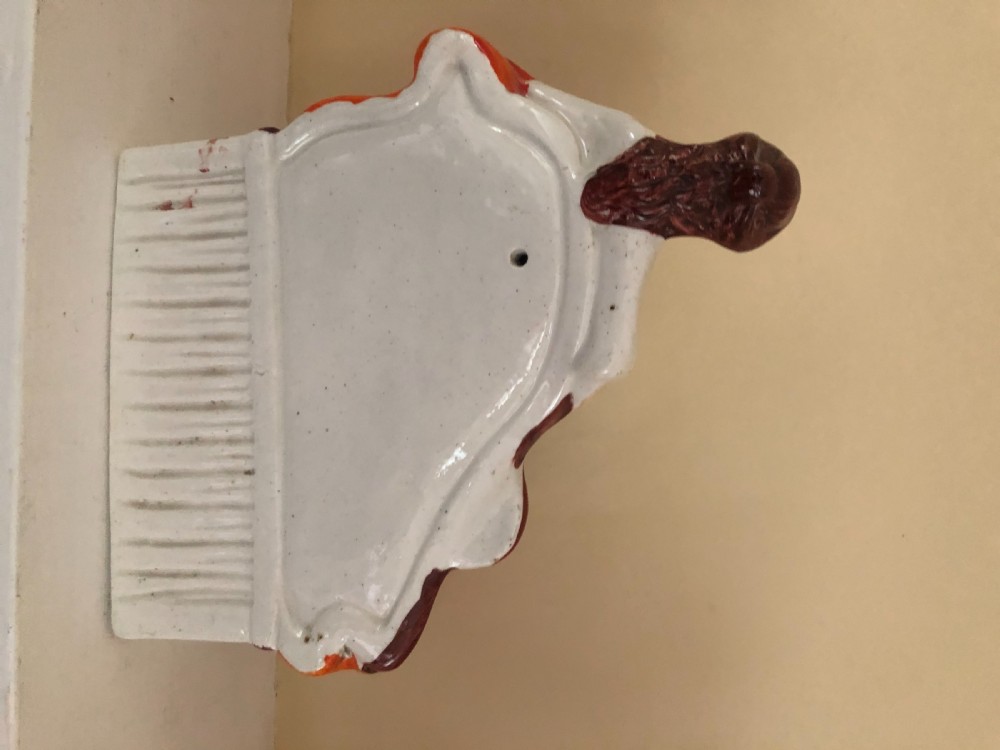 A Staffordshire Figure of a Lady reclining on a chaise longue with a mandolin in one hand and a book in another. View II