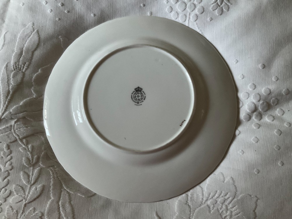 A circular Royal Worcester bone china plate featuring a yellow border with gold scrollwork surrounding a white centre with a hand-painted floral bouquet. View II