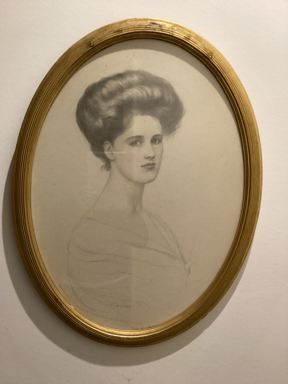 An oval gilt-framed drawing showing a profile-three-quarter portrait of an Edwardian woman with swept-up hair rendered in pencil and delicate wash. View II