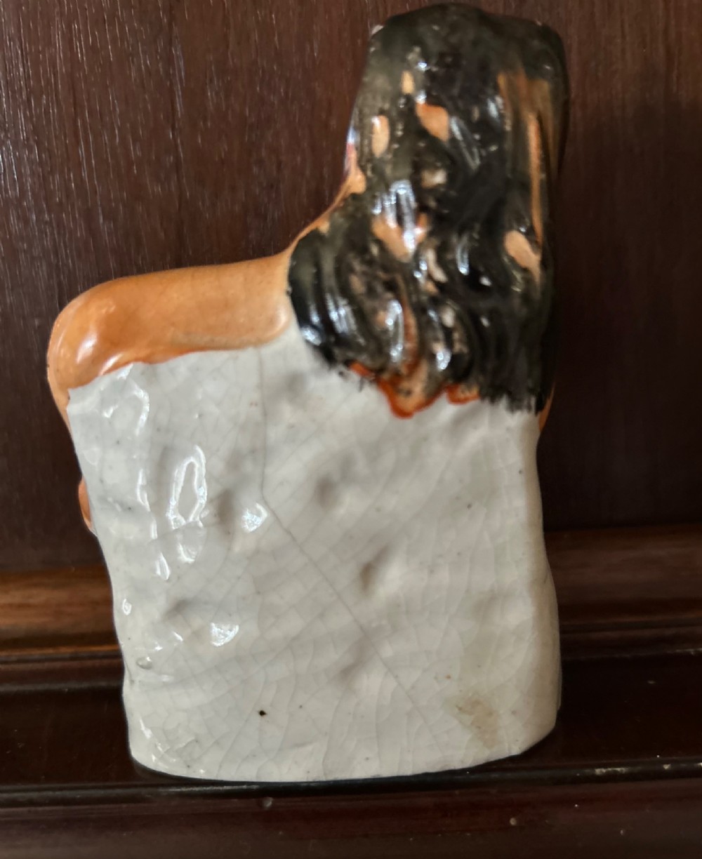 A Victorian Staffordshire pottery figure depicting a tawny-painted standing lion situated above a small white lamb on an integral moulded base. View II