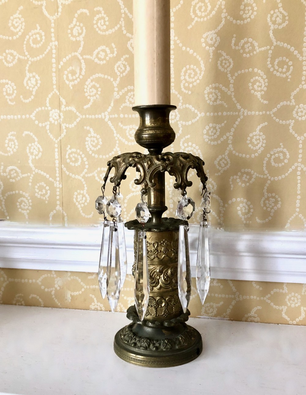 A pair of 19th-century gilt metal candlesticks featuring embossed relief columns and suspended cut-glass prism drops. View II