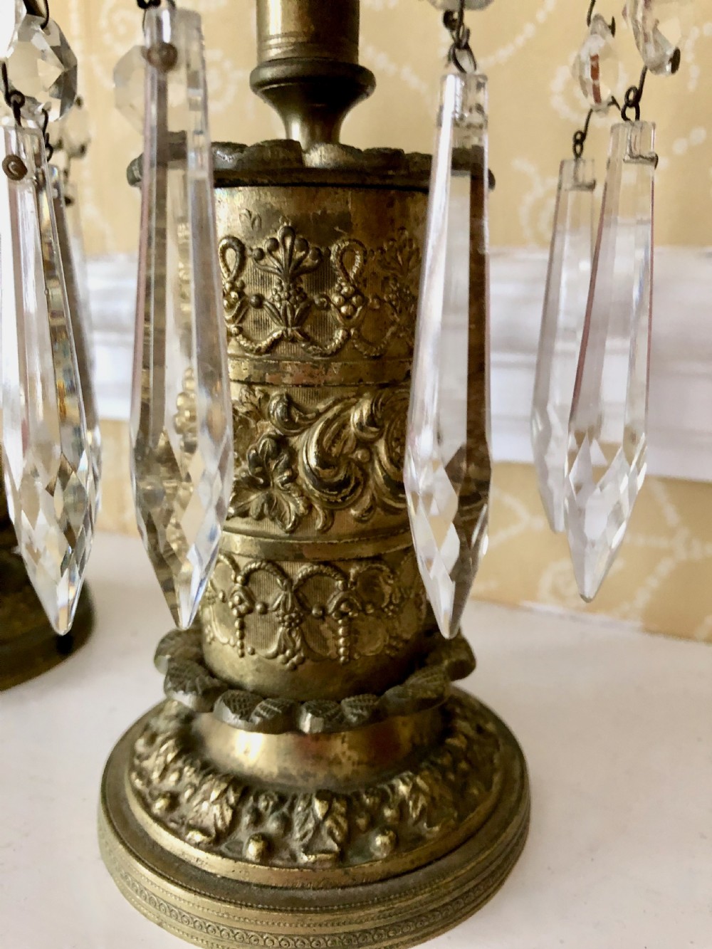 A pair of 19th-century gilt metal candlesticks featuring embossed relief columns and suspended cut-glass prism drops. View III