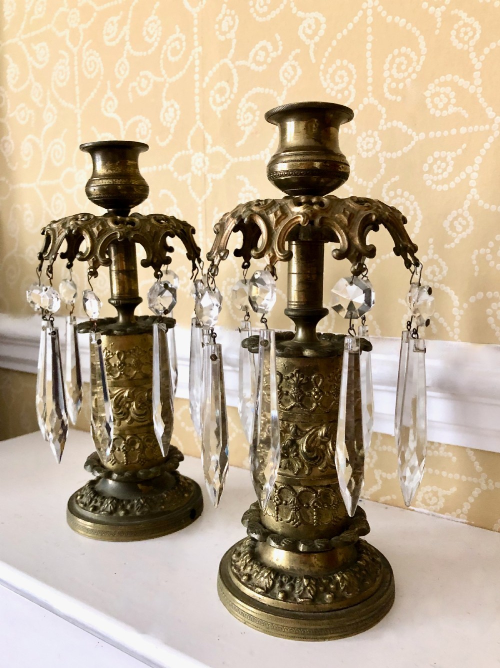 A pair of 19th-century gilt metal candlesticks featuring embossed relief columns and suspended cut-glass prism drops. View IV