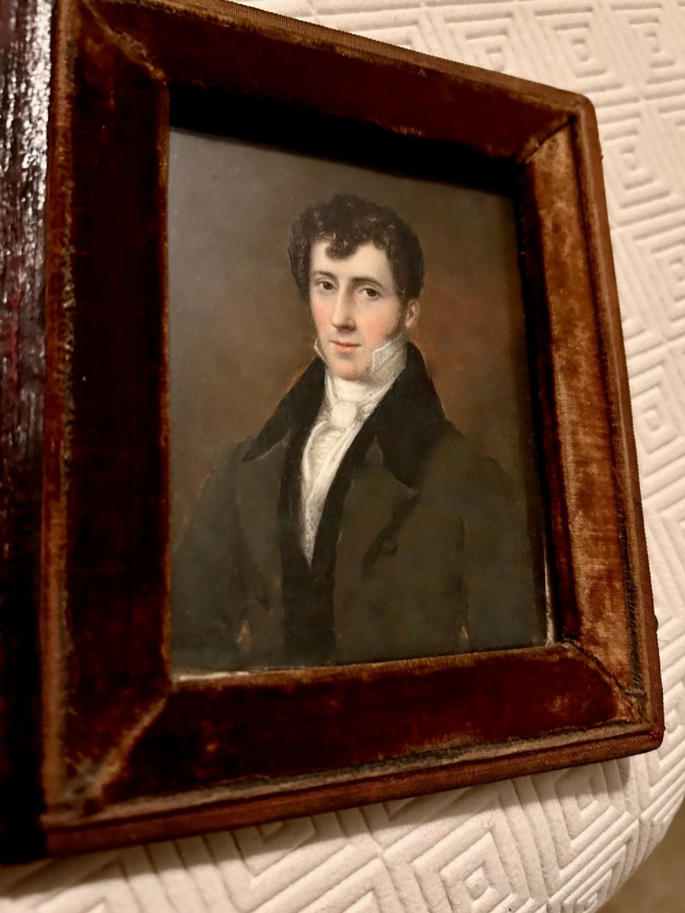An early Victorian portrait miniature painting depicting a gentleman in a dark coat, housed within a red velvet-lined folding case. View III