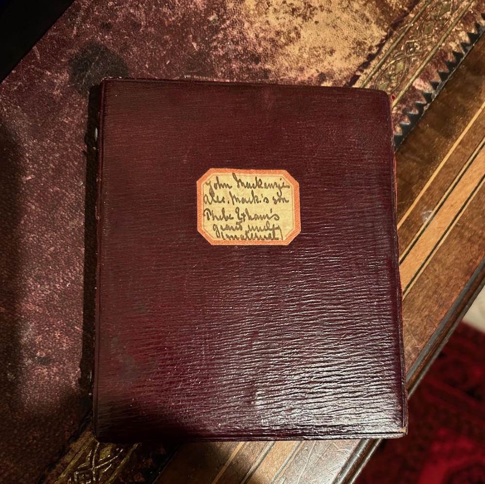 An early Victorian portrait miniature painting depicting a gentleman in a dark coat, housed within a red velvet-lined folding case. View VI
