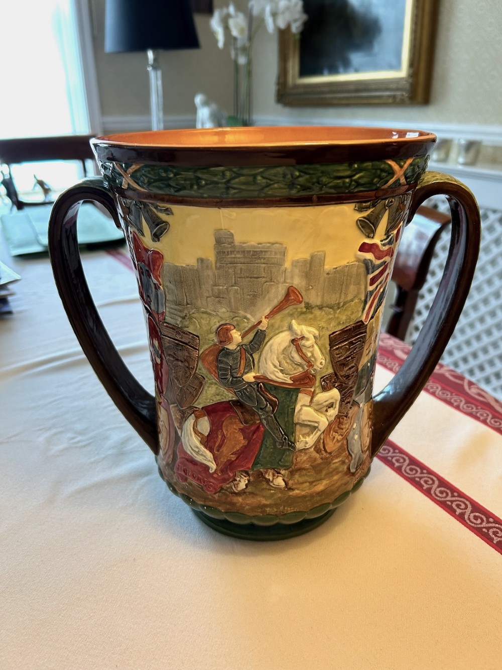A brown glazed earthenware twin-handled loving cup featuring relief-moulded profile portraits of King George VI and Queen Elizabeth dated 1937. View VI
