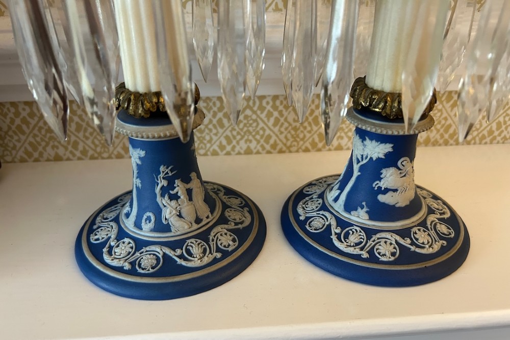 A pair of Victorian candle lustres featuring cobalt blue jasperware bases with white classical reliefs, topped with fluted column shafts, gilt sconces, and hanging cut glass crystal prisms. View II