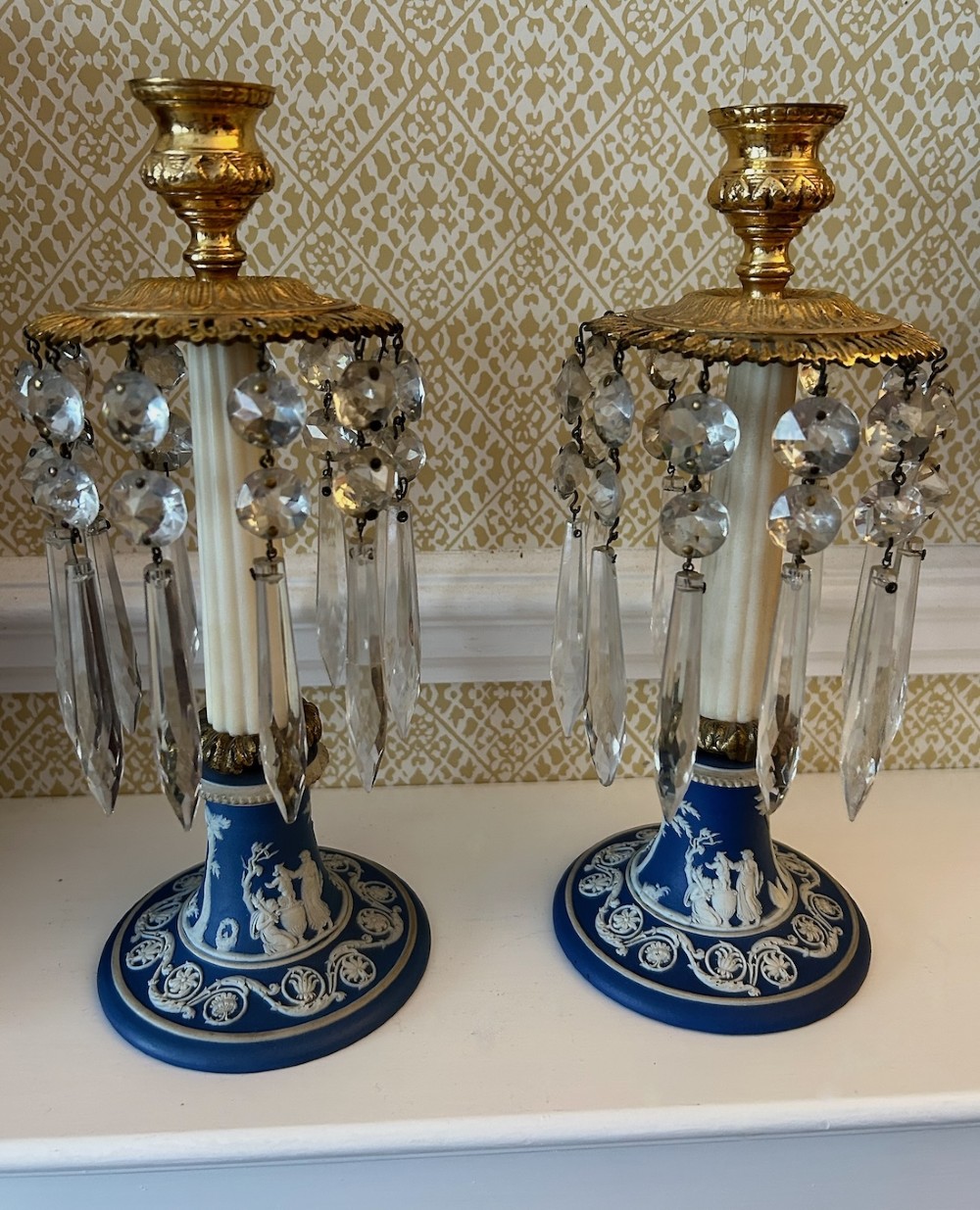 A pair of Victorian candle lustres featuring cobalt blue jasperware bases with white classical reliefs, topped with fluted column shafts, gilt sconces, and hanging cut glass crystal prisms. View IV
