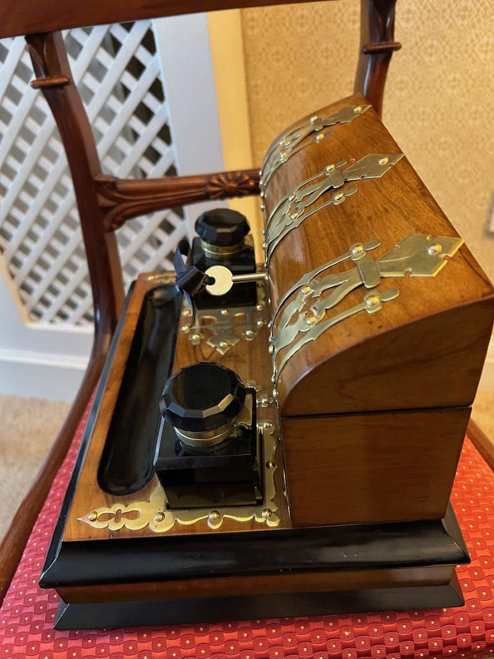 An open Victorian figured walnut desk stand featuring decorative brass strapwork, two black inkwells, a pen trough, and an upper stationery compartment lined in blue fabric. View IV