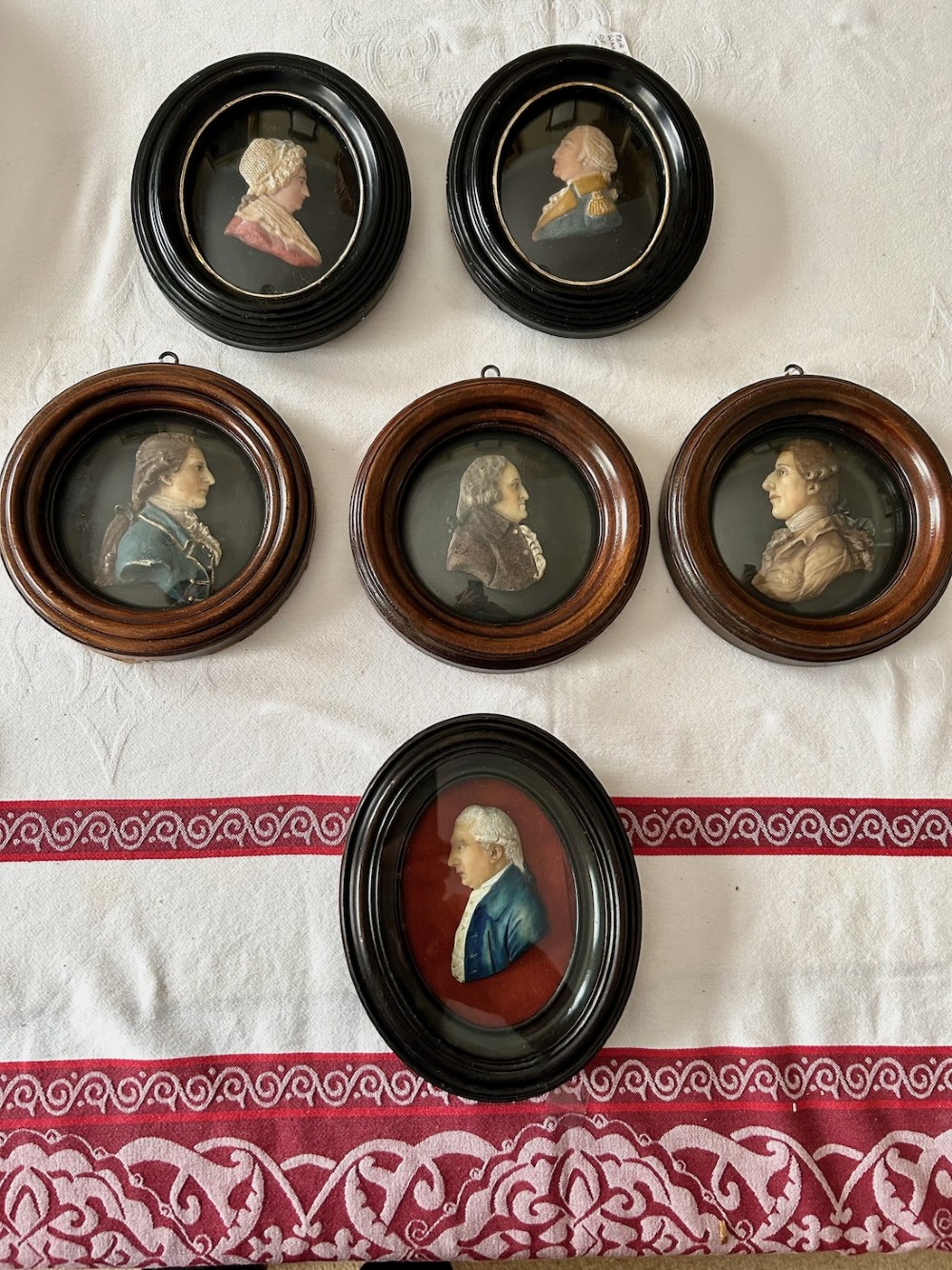 A set of six antique wax profile relief portraits depicting historical figures set inside round and oval turned wooden frames. View V