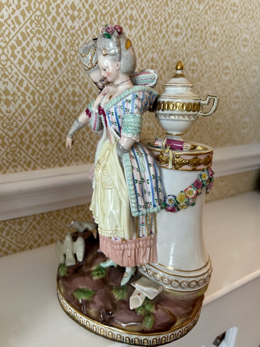A pair of 19th-century hand-painted Meissen porcelain figurines depicting figures in 18th-century court dress alongside classical urns. View VIII