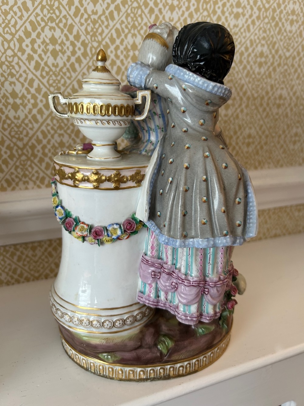 A pair of 19th-century hand-painted Meissen porcelain figurines depicting figures in 18th-century court dress alongside classical urns. View XII