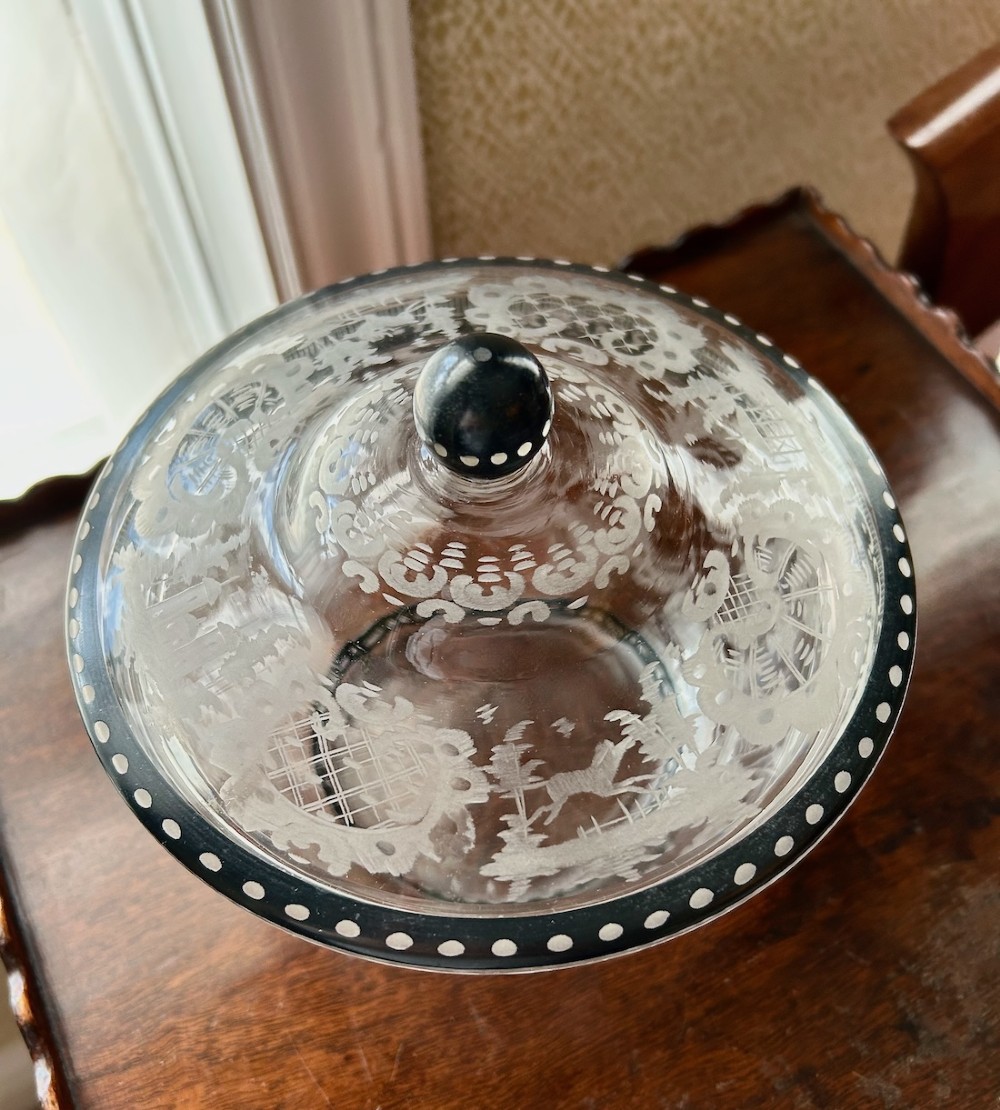 An antique clear glass bowl and lid featuring intricate wheel-engraved forest motifs and black enamelled borders with white dot detailing. View II