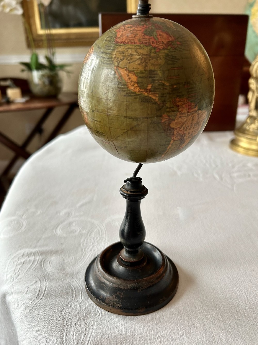 A small 1920s Geographia terrestrial globe featuring printed paper gores set upon a dark turned wooden pedestal stand. View II