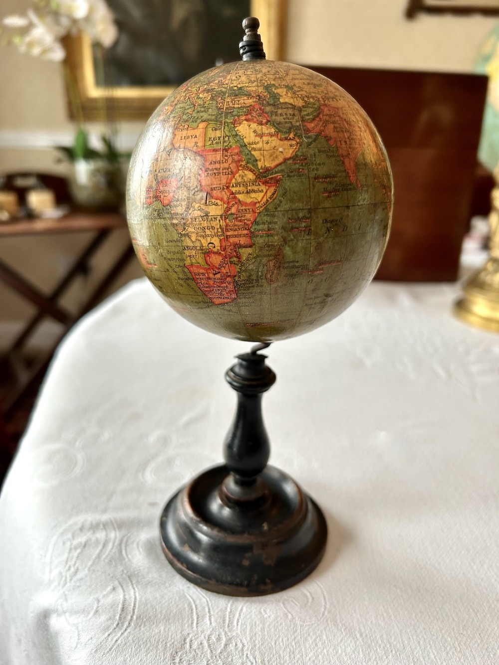 A small 1920s Geographia terrestrial globe featuring printed paper gores set upon a dark turned wooden pedestal stand. View VI