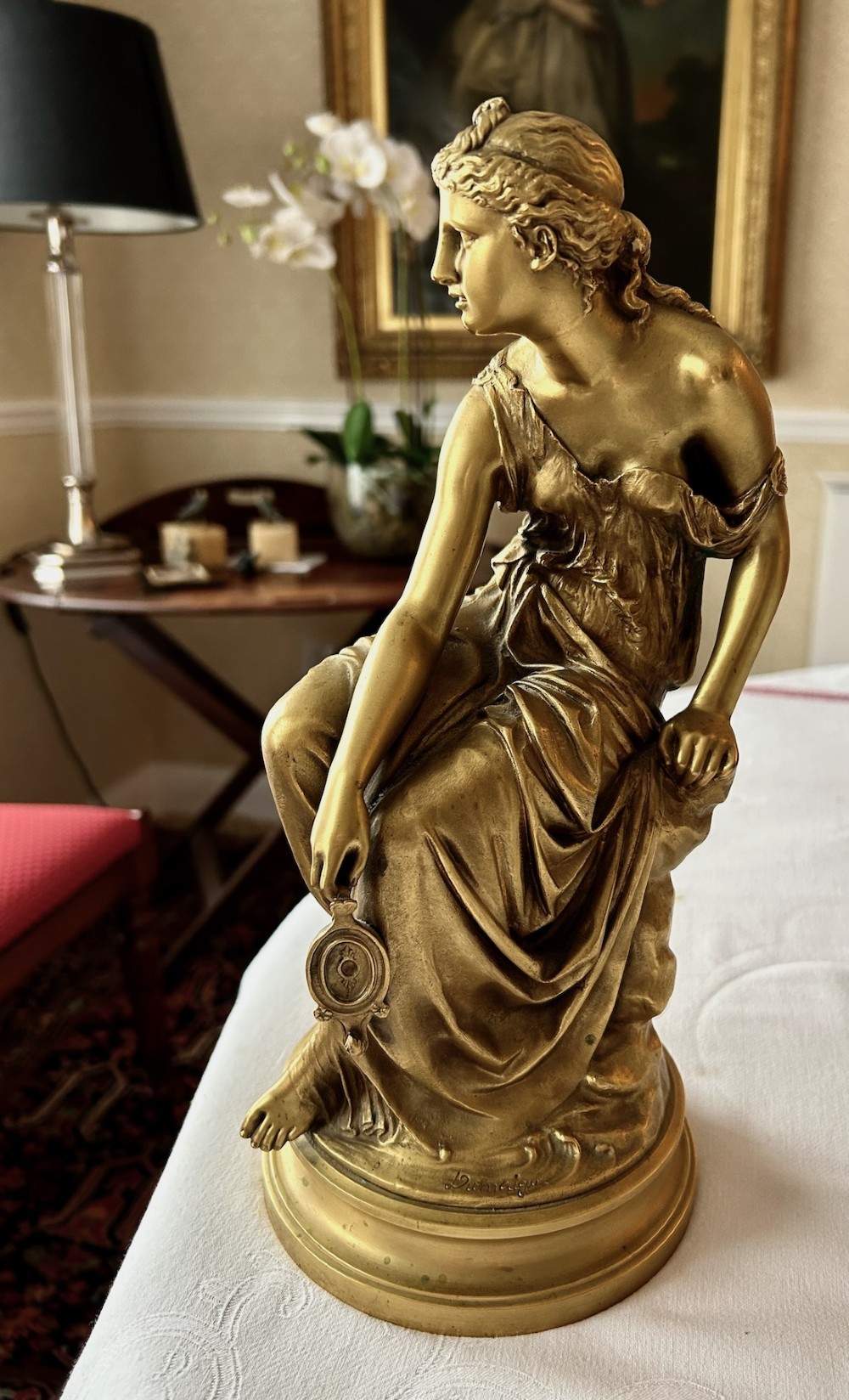 A nineteenth-century French gilt bronze figure depicting a draped classical maiden seated on a circular base. View IV