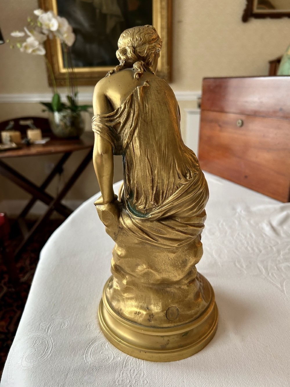 A nineteenth-century French gilt bronze figure depicting a draped classical maiden seated on a circular base. View VI