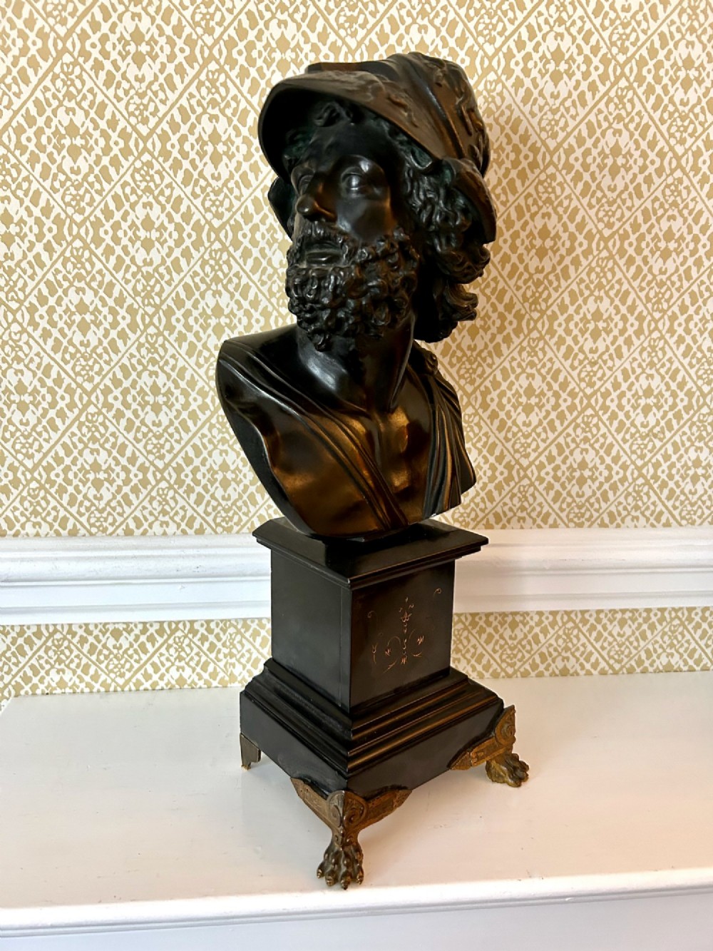 A 19th-century dark bronze bust depicting the classical figure Ajax wearing a crested helmet, mounted on a black marble pedestal with gilt feet. View II