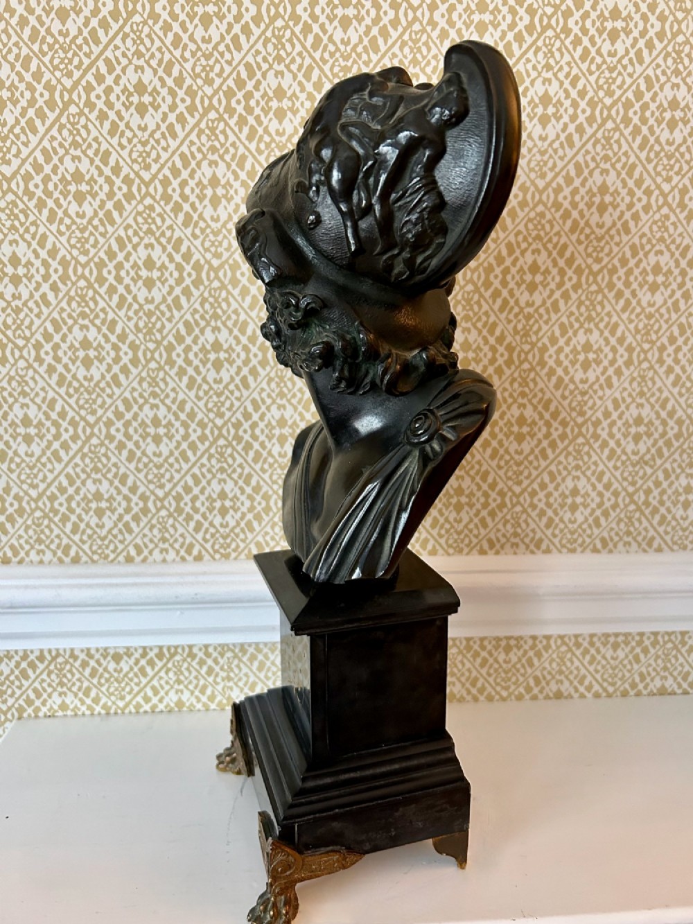 A 19th-century dark bronze bust depicting the classical figure Ajax wearing a crested helmet, mounted on a black marble pedestal with gilt feet. View III