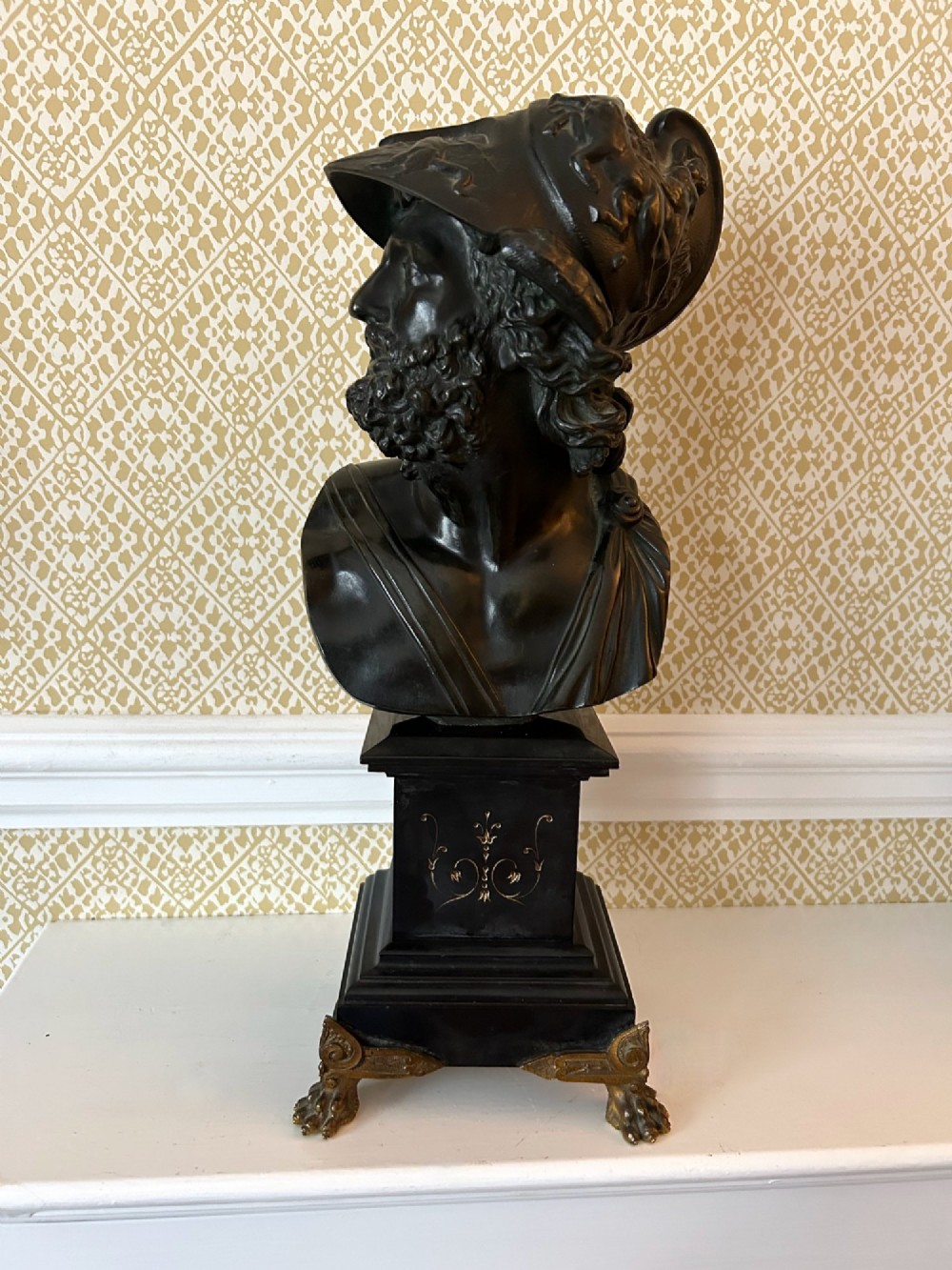 A 19th-century dark bronze bust depicting the classical figure Ajax wearing a crested helmet, mounted on a black marble pedestal with gilt feet. View IV