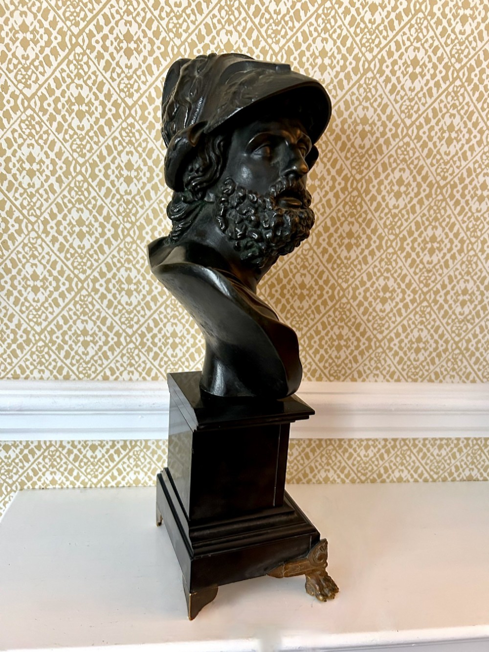 A 19th-century dark bronze bust depicting the classical figure Ajax wearing a crested helmet, mounted on a black marble pedestal with gilt feet. View VI