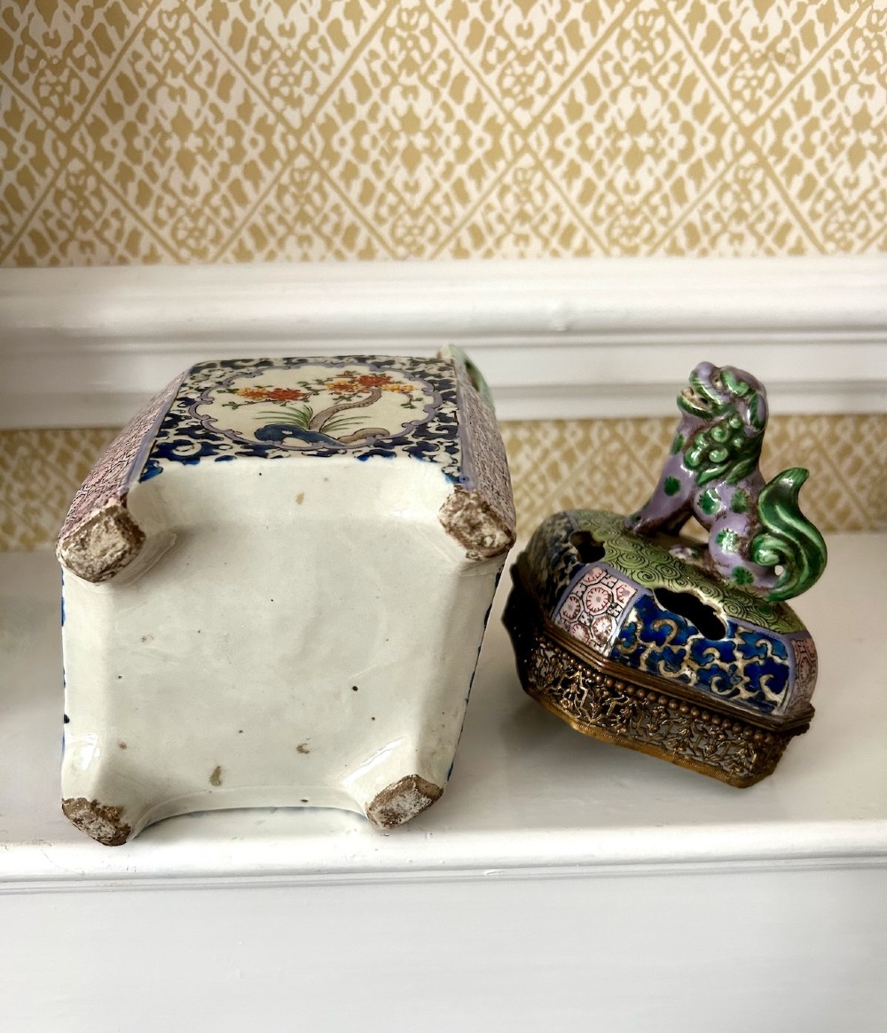 A square 19th-century Chinese porcelain censer featuring a purple foo lion finial on the lid, detailed polychrome enamel floral panels, and blue scrollwork borders. View VI