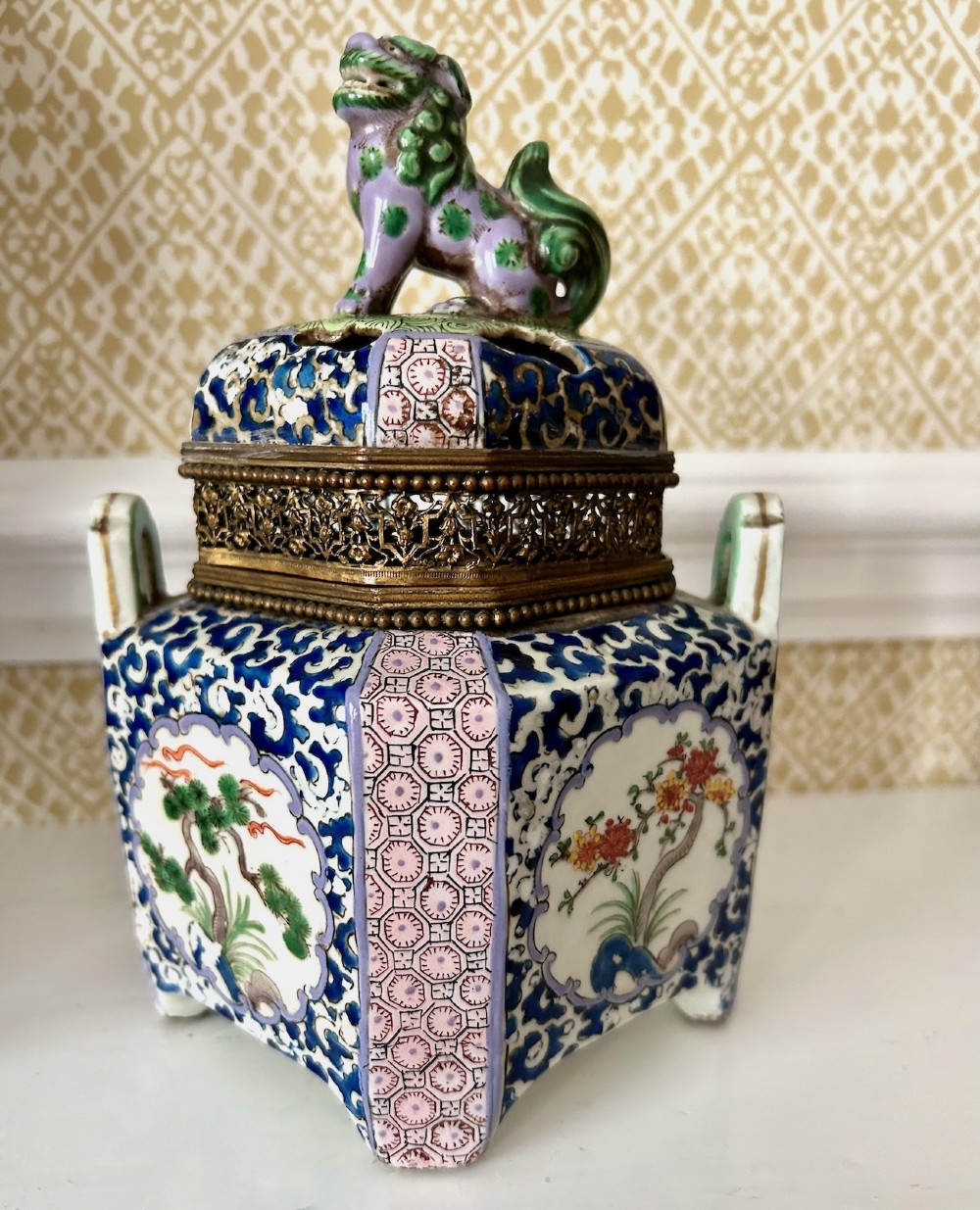 A square 19th-century Chinese porcelain censer featuring a purple foo lion finial on the lid, detailed polychrome enamel floral panels, and blue scrollwork borders. View VII