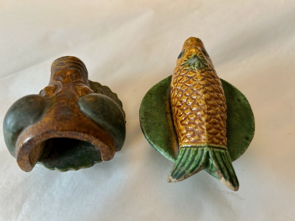 A pair of Chinese Sancai lead-glazed earthenware altar offerings depicting a boars head and a fish on circular dish bases. View II