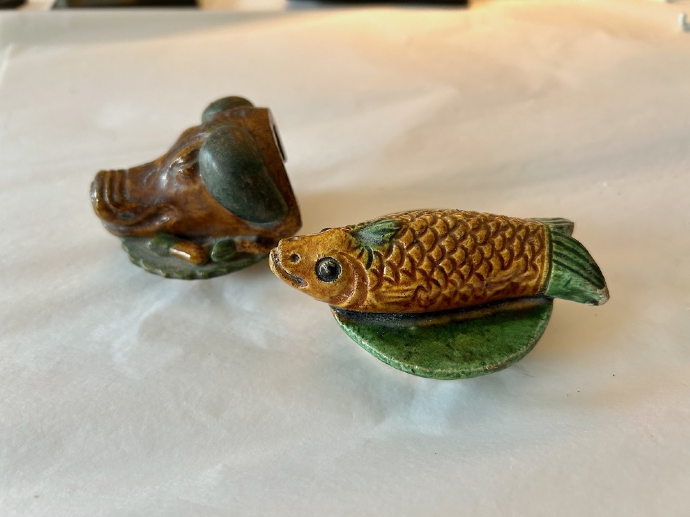 A pair of Chinese Sancai lead-glazed earthenware altar offerings depicting a boars head and a fish on circular dish bases. View V
