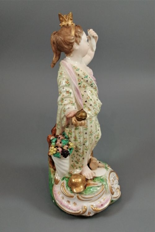 fig 1. An 18th-century Derby soft-paste porcelain statuette representing Europe, featuring a crowned figure in patterned drapery standing on a gilded scrollwork base.