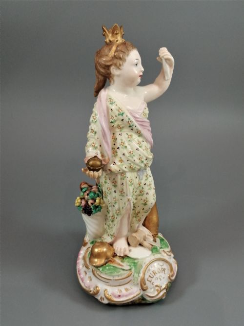 fig 2. An 18th-century Derby soft-paste porcelain statuette representing Europe, featuring a crowned figure in patterned drapery standing on a gilded scrollwork base.