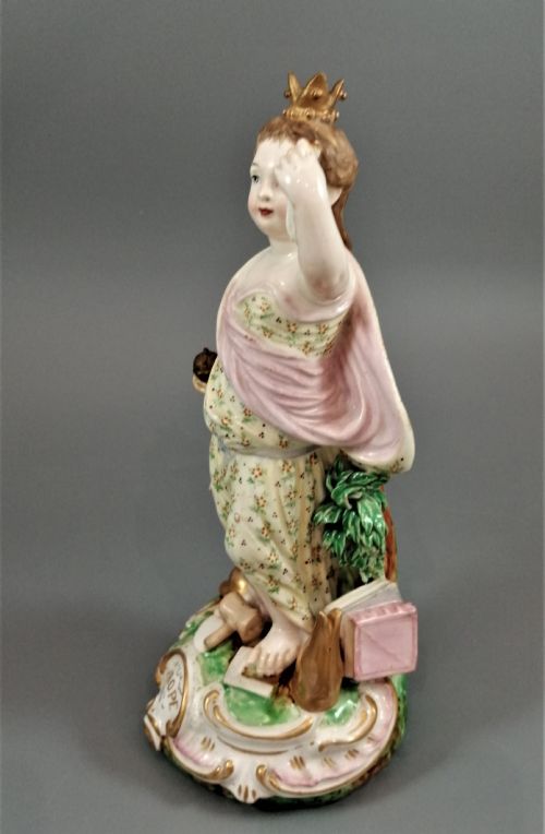 fig 3. An 18th-century Derby soft-paste porcelain statuette representing Europe, featuring a crowned figure in patterned drapery standing on a gilded scrollwork base.