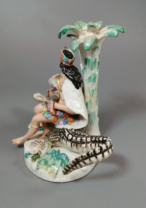 fig 2. An 18th-century Chelsea polychrome porcelain statuette depicting an allegorical female figure seated on an alligator beside a palm tree.