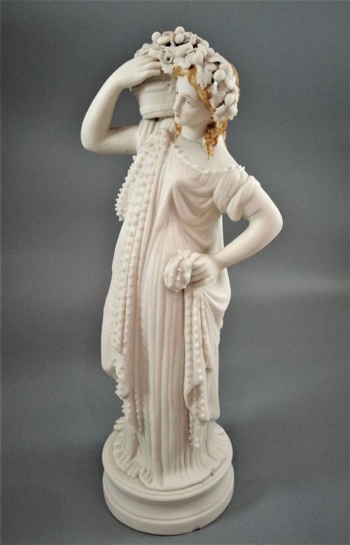 fig 1. A nineteenth-century Victorian Parian ware figurine depicting a classically draped maiden holding a fruit basket on her shoulder.