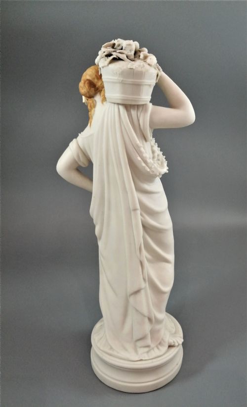 fig 3. A nineteenth-century Victorian Parian ware figurine depicting a classically draped maiden holding a fruit basket on her shoulder.