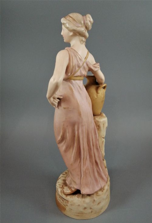 fig 2. A Royal Dux porcelain statuette of a classical maiden in a draped dusty pink gown holding an earthenware jug.