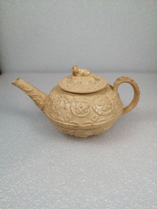 fig 1. A small caneware teapot with a spaniel finial. Wedgwood, C.1800