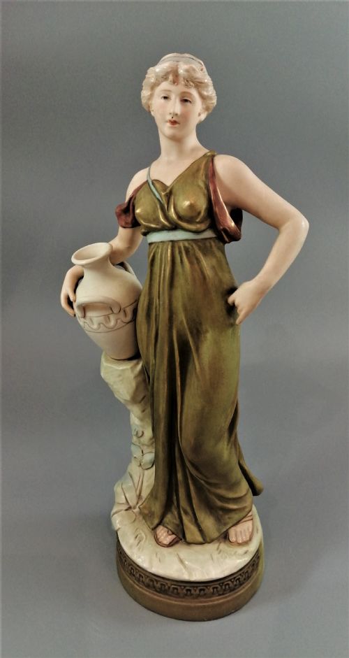 Beautiful Antique Royal Dux Porcelain Figurine Depicting a Lady Holding a Jug.