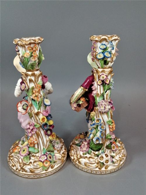 fig 3. A pair of hand-painted Minton porcelain figural candlesticks featuring a male and female figure in colourful traditional dress with floral motifs and gilded scroll bases.