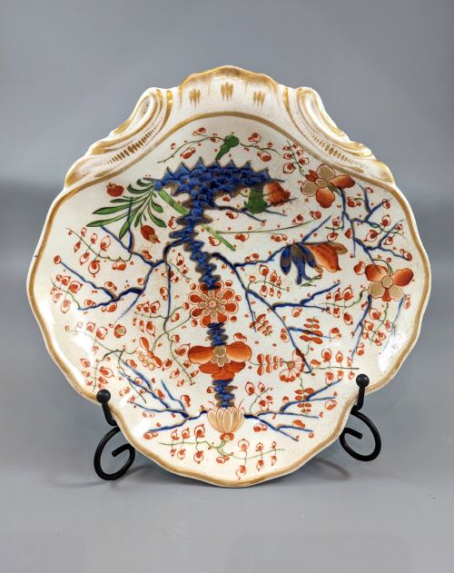 fig 1. An antique shell-shaped porcelain plate featuring hand-painted Kakiemon-style motifs of two quails beneath flowering branches with gilt highlights.