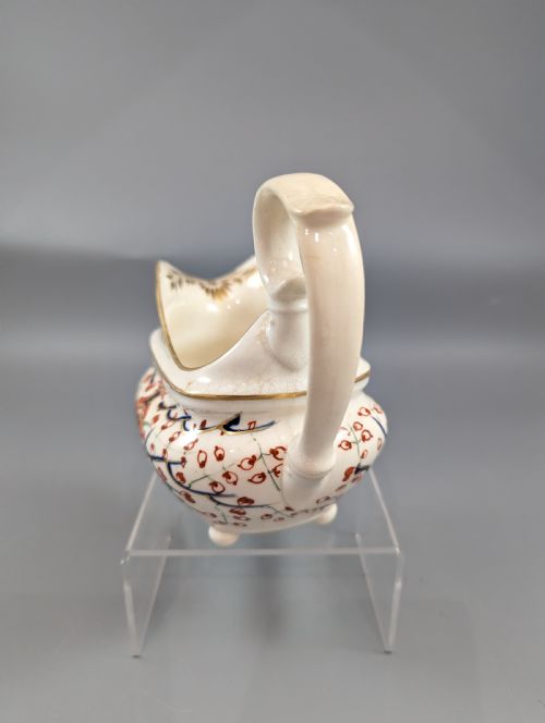 fig 2. An antique cream-coloured porcelain jug featuring a hand-painted Two Quails design with gilded rim detailing and a raised loop handle.