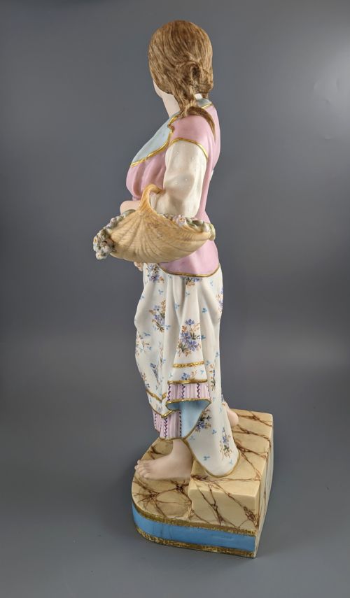 fig 4. A Victorian coloured Parian porcelain figure depicting a draped female figure holding a basket of flowers on a faux-marble painted base.