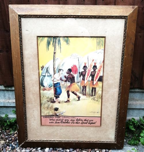 fig 1. A framed 1930s colour travel agency cartoon advertisement illustrating a scene with a traveler tied to a tree near tropical huts and a cooking pot.