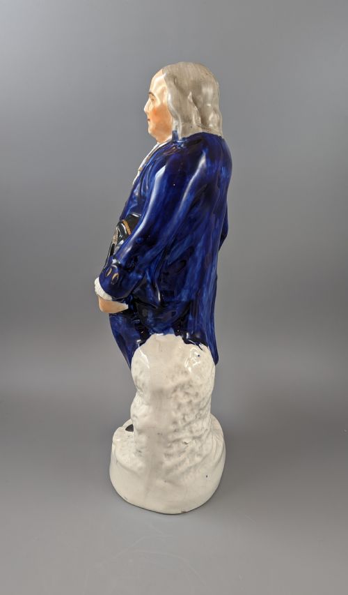 fig 3. A Victorian Staffordshire earthenware figure of Benjamin Franklin standing in a cobalt blue coat and holding a tricorn hat, set on a pedestal inscribed Washington.