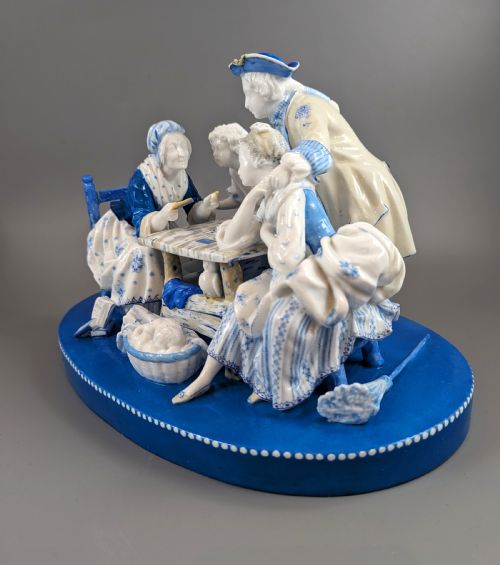 fig 1. Late 19th-century French blue and white glazed porcelain figurine group depicting four figures gathered around a table fortune-telling on an oval blue base.